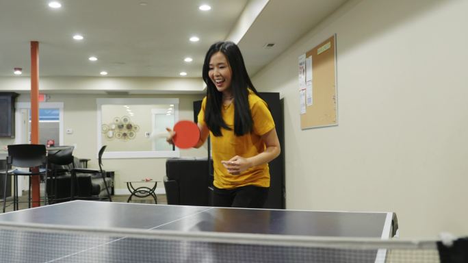 在办公室休息室打乒乓球的女人