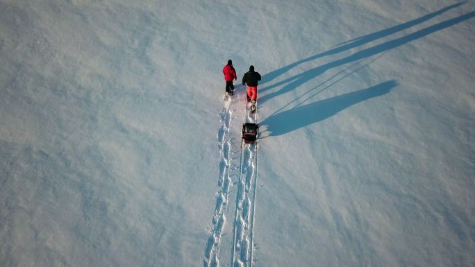 4K鸟瞰视频家庭雪鞋在冬季日落时户外