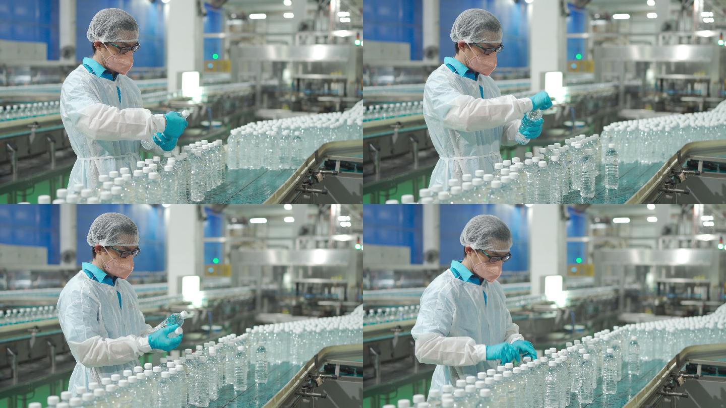 中国亚裔男性饮用水厂生产线工人，戴着个人防护用品，在日常工作中检查水瓶