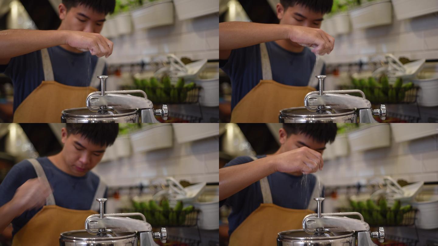 亚洲华人面包师少年男孩在厨房的立式搅拌机中添加面粉