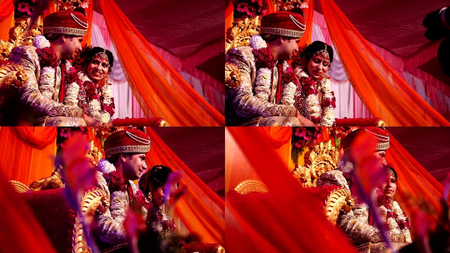 多莉拍摄的印度新婚夫妇坐在豪华沙发上，他们在婚礼舞台上互相交谈