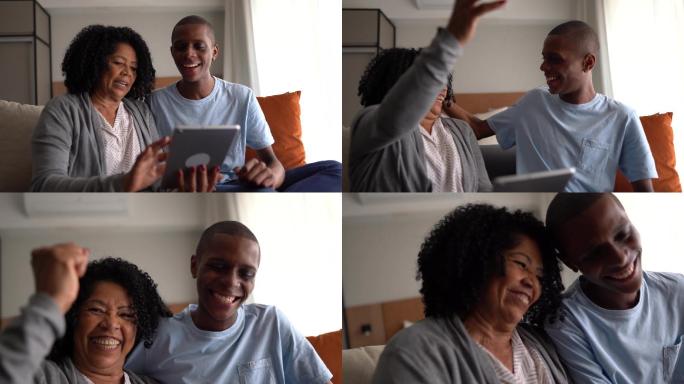 祖母和孙子使用数字平板电脑，有好消息/在家获胜