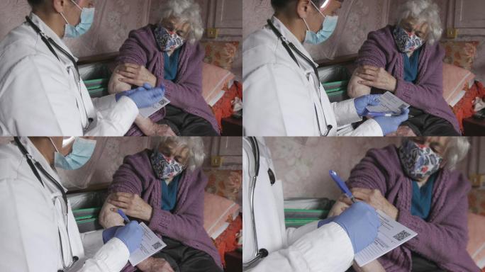 向家中的老年妇女发放2019冠状病毒疾病疫苗接种证书。