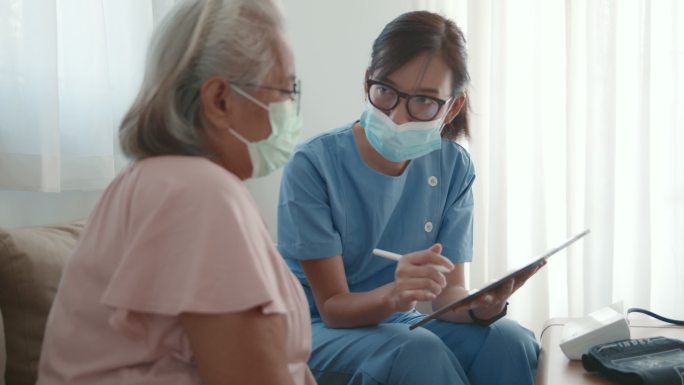 医生在家里的起居室为老年女性提供咨询。