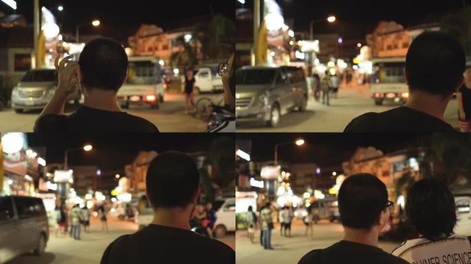 下面是两名泰国男子旅行者夜间在万荣步行的后视图