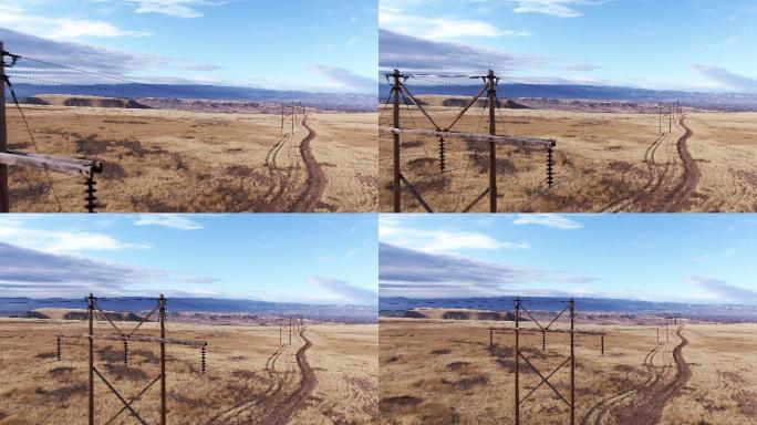 在多云的天空下，无人驾驶飞机在科罗拉多州西部的一条土路和一片棕色草地上拍摄了电线，背景是科罗拉多国家