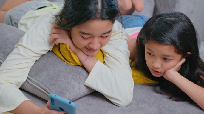 使用数字技术的兄弟姐妹。在家使用手机智能手机和数字平板电脑。