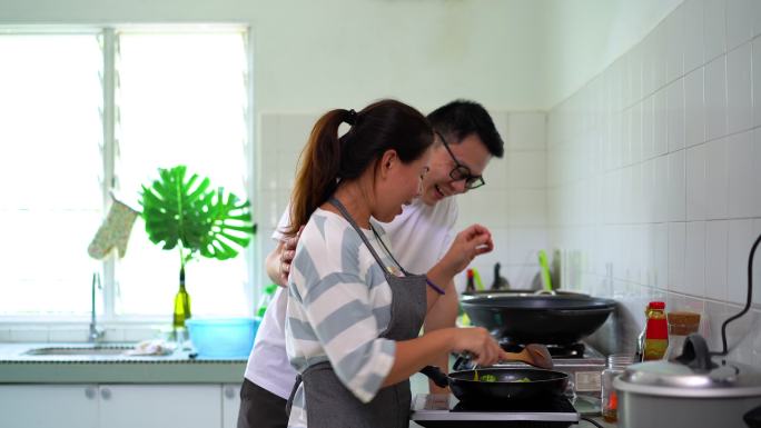 亚洲华人男女在厨房炒杂菜