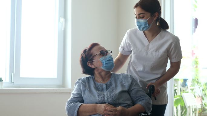 带坐在轮椅上的女性的护理者