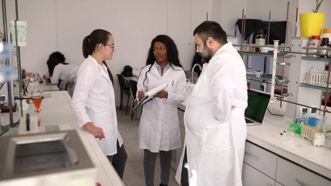 一组化学家站在一个现代化的实验室里，组织了一次科学实验。