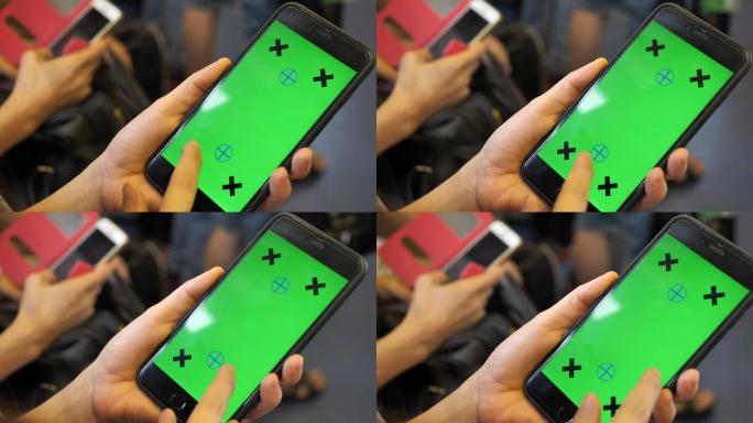 地铁列车上使用智能手机的女性，绿色屏幕