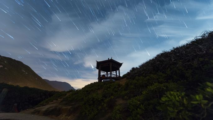 夏季银河星轨流星雨下的亭子和高山