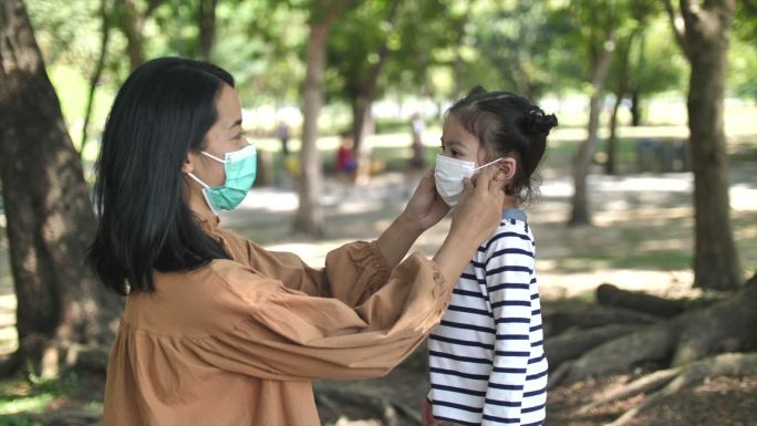 母亲给女儿戴上医用面罩