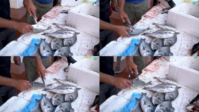 一名男子在鱼市清理和准备出售鱼类的4K视频片段