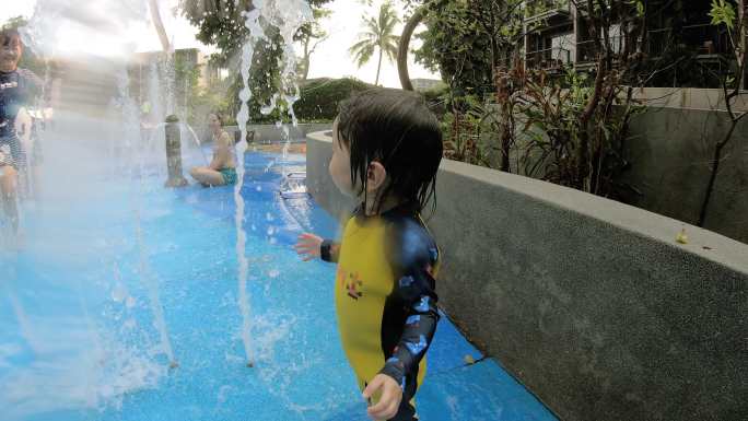 亚洲小女孩和家人在水上公园玩耍。