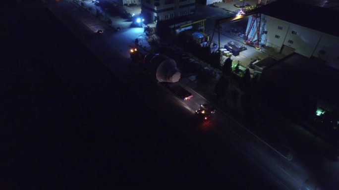 夜间无人驾驶飞机拍摄大型物流车队-工业区卡车运输大型物体