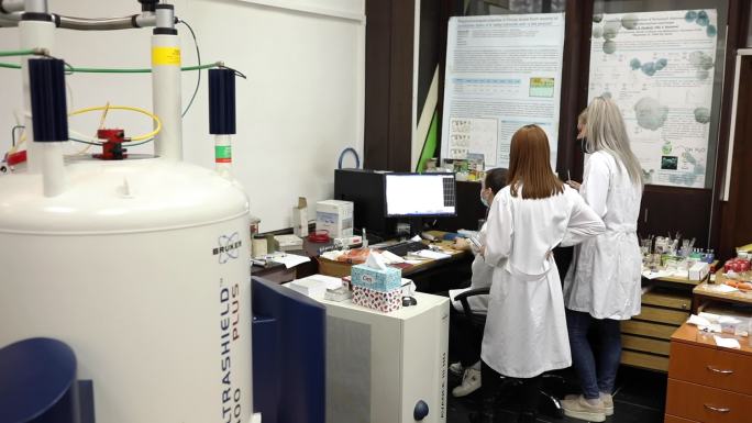 在现代大学实验室，学生们观察和分析核磁共振数据