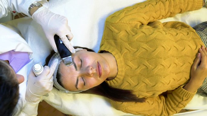 一名年轻女子在美容院的库存视频中接受射频提升程序