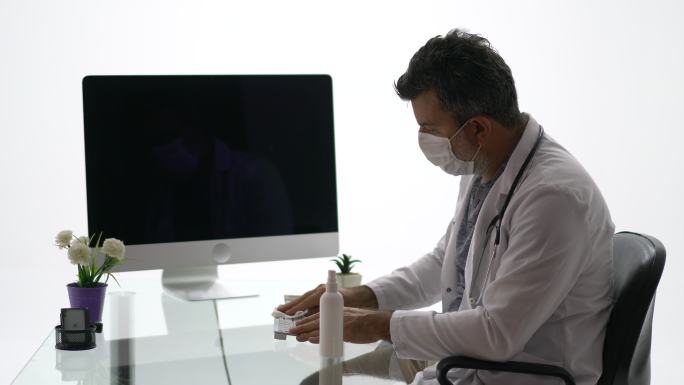 男医生用抹布给电脑键盘消毒。
