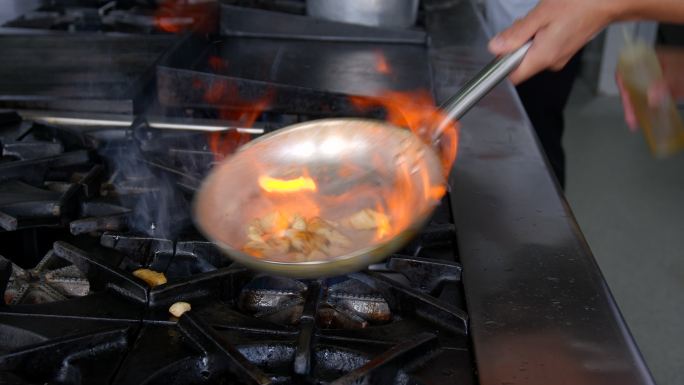 餐厅一位面目全非的厨师在平底锅里煎鸡肉的特写镜头