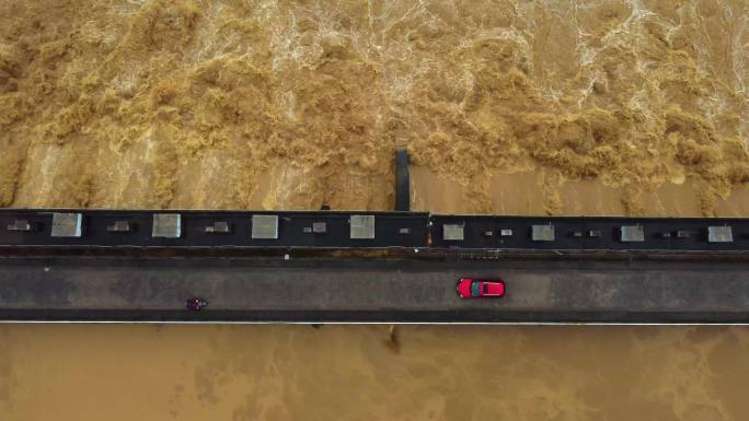 红色轿车驶过水坝桥航拍水坝泄洪排涝排水