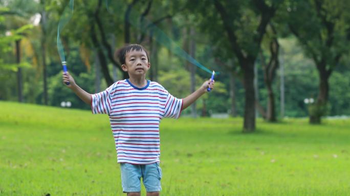 小男孩在草地上跳绳