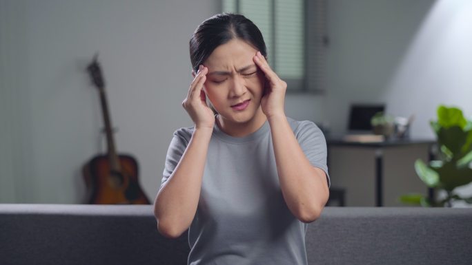一位亚洲妇女头痛。