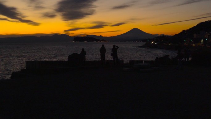 人们在拍照。黄昏时分从稻村崎到富士山和宜诺斯hima岛