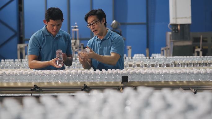 亚裔中国检查员在制造厂水瓶工厂展示新学员