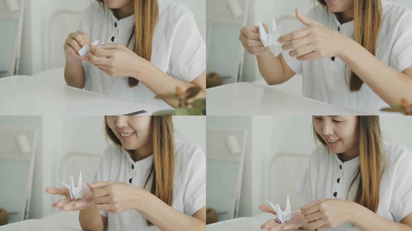 一名泰国女子在房间里用折纸工艺diy自己动手折纸，一边用积极的情绪折一只鸟