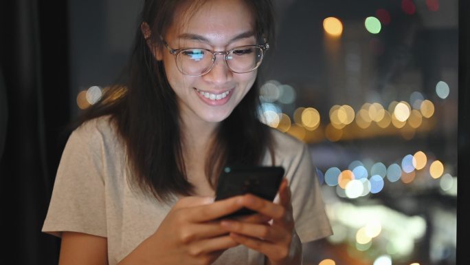 亚洲Gen-z大学开朗的学生戴眼镜在卧室晚上使用手机购物电子商务