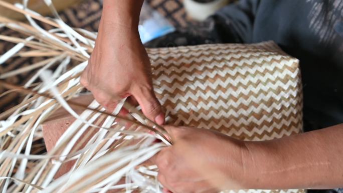 女织工的特写手编织制作篮子的干叶，篮子的手工制作