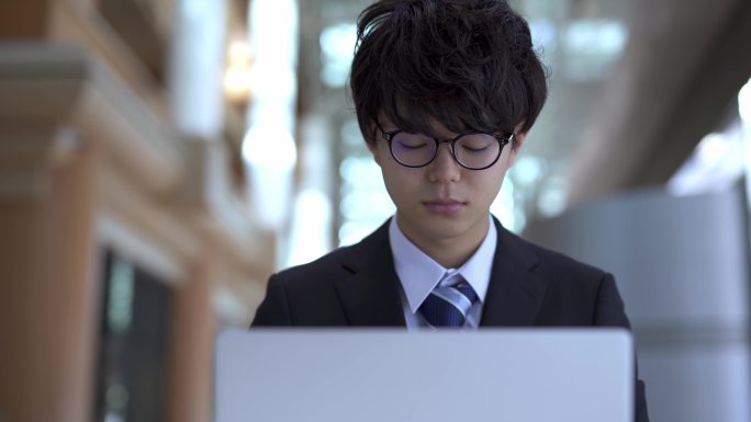亚洲男人使用笔记本电脑，