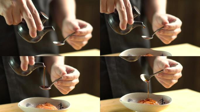 餐厅厨房里的厨师正在用日本料理将日本酱汁倒在碗里
