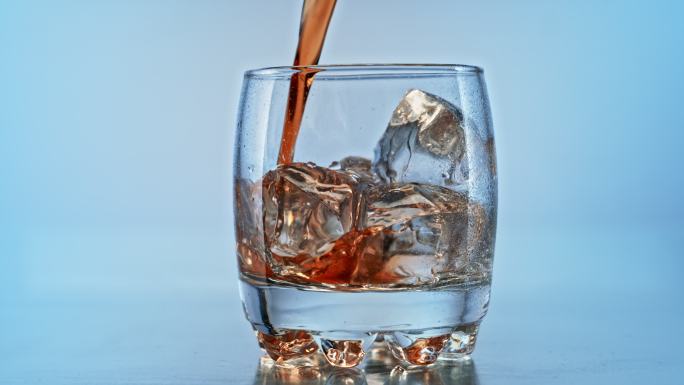 将斯洛莫尔德威士忌倒入装有冰块的玻璃杯中