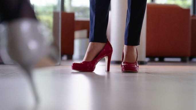 穿着红色高跟鞋的女商人的腿