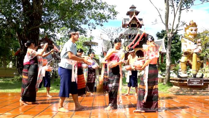 慢镜头：美丽的女人穿着泰国传统服装在寺庙泼水-泼水节