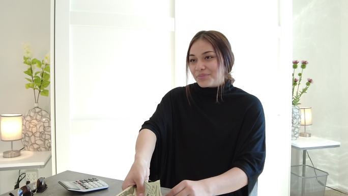 西班牙裔Z代女性预算和计算货币年轻人在家工作，使用4K视频技术