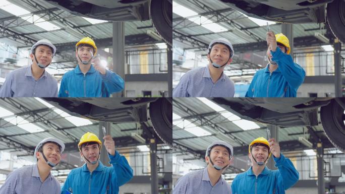 两名亚洲人在汽车修理厂戴头盔工作。车辆服务经理团队男性工人查看车辆状况，检查和维护，以便在车间维修发