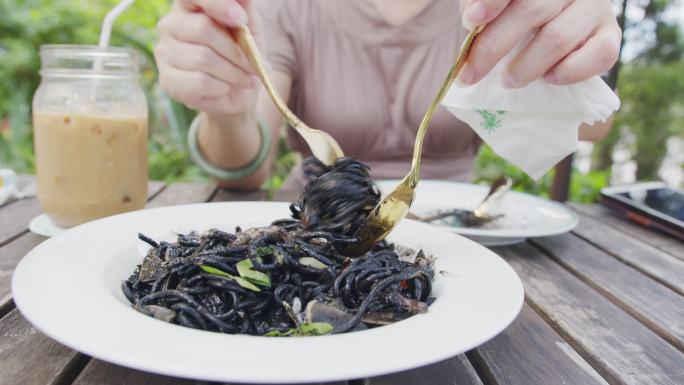 顾客在滚黑色鱿鱼意大利面