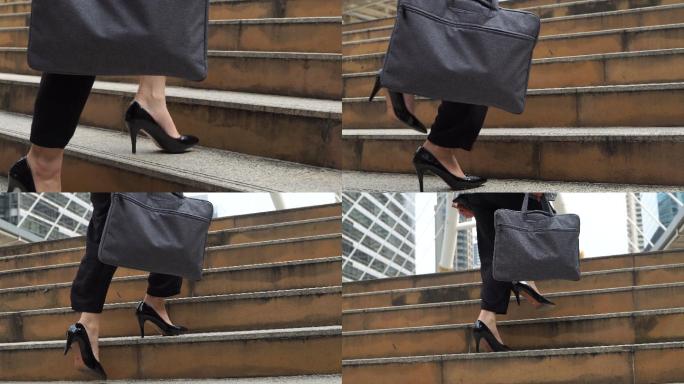 高跟鞋亚洲女性拿着笔记本电脑走上楼梯