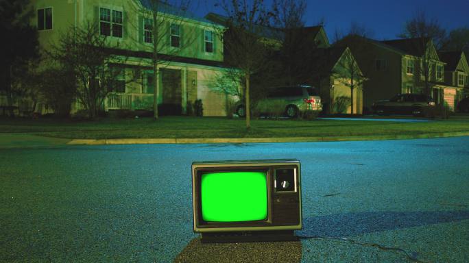 夜晚荒芜街道上的彩色按键复古电视