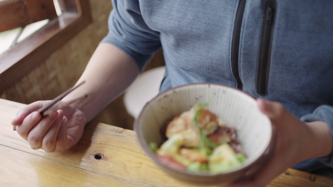 饥肠辘辘的亚洲人吃的是丹贝汉堡饭碗和冷豆腐。