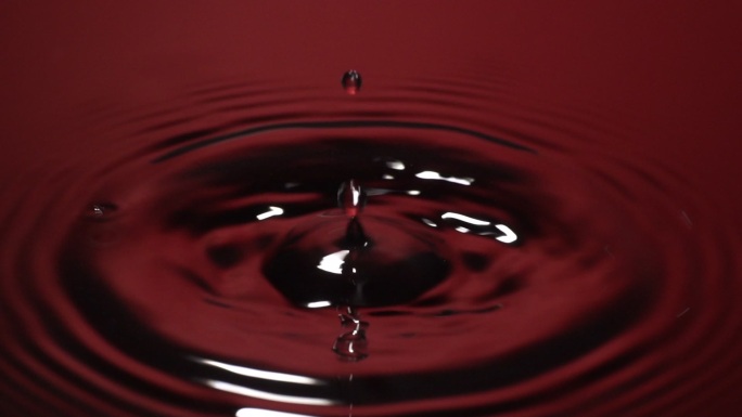 慢动作：水滴落入红色水中。