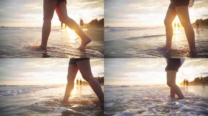 逆光夕阳下海滩脚步金色海水走向水中