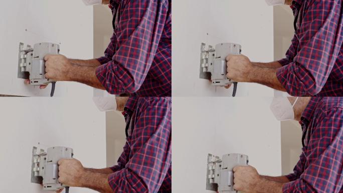 西班牙裔高级木匠用拼图切割胶合板，用于自己家的厨房改造。