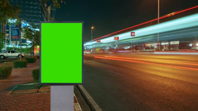 随着时间的推移，道路上的交通长期暴露在广告牌绿色屏幕上，用于广告城市的街道标志。