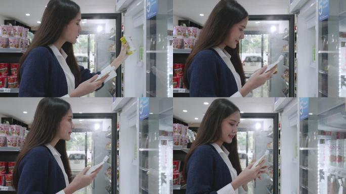 女人在冰箱里选择饮用水，穿着蓝色休闲装的亚洲女商人正在购物和服务