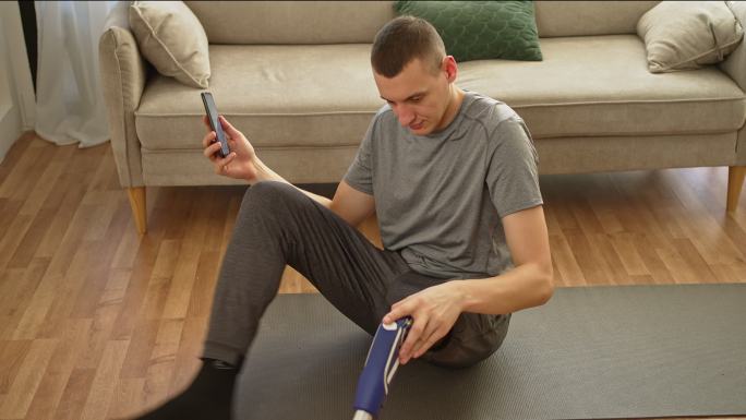 一名年轻男子在运动休息时用手机做假腿