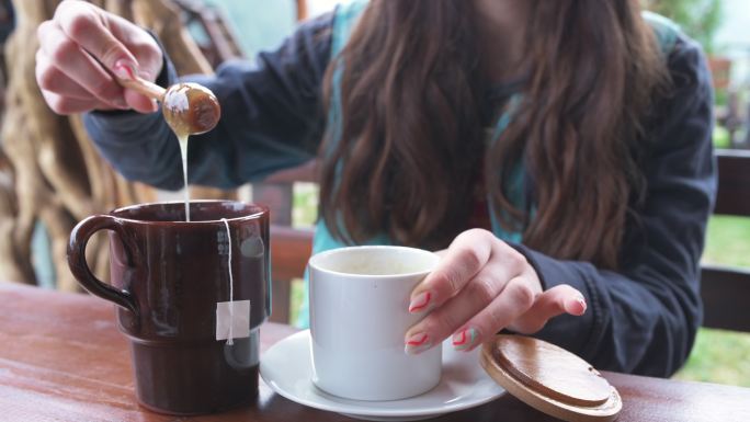 那个女人正在茶里放天然蜂蜜。